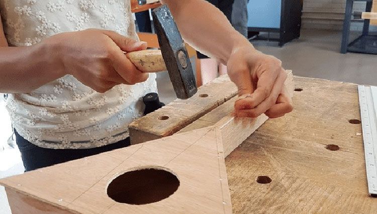 Basisschoolleerling maakt een houten balalaika