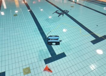 Onderwaterdrone in het zwembad om met robotarm pilon en stoel te pakken