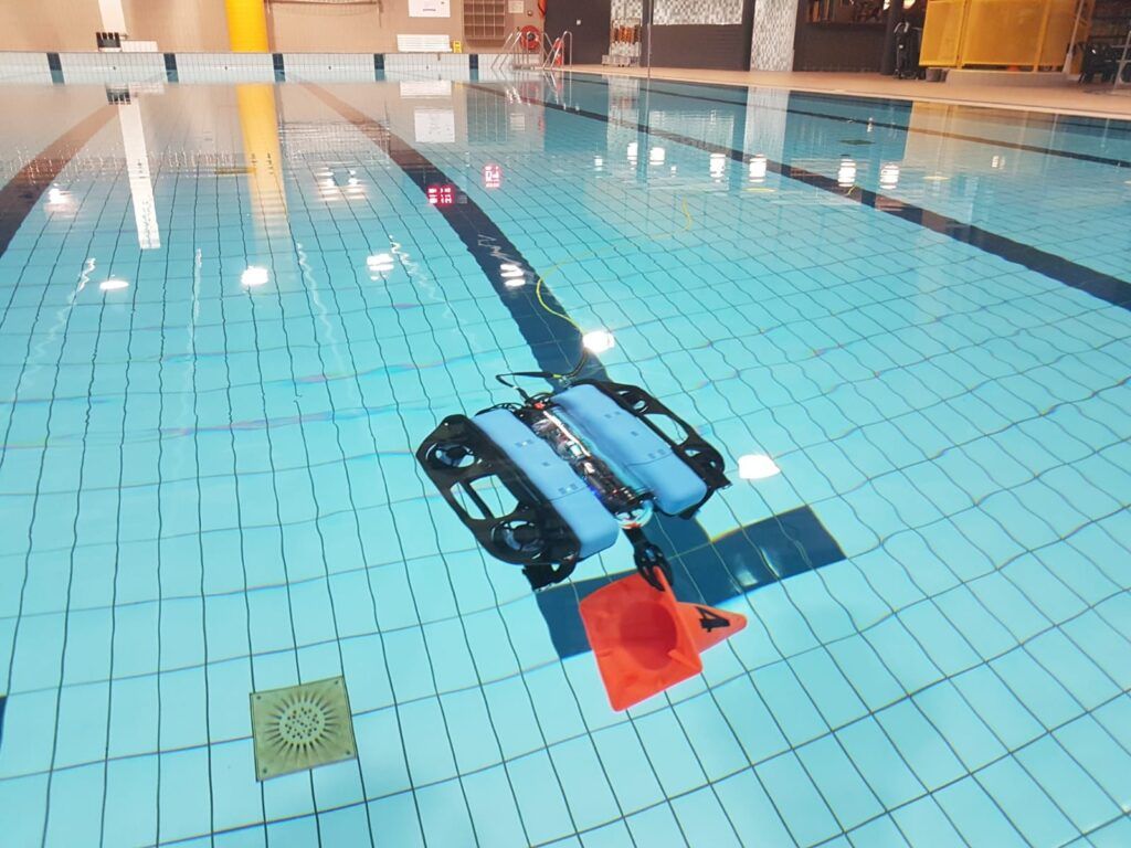 Onderwaterdrone met pilon in het zwembad