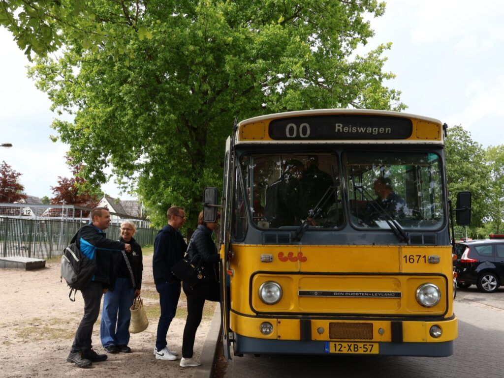 Deelnemer stappen in de historische bus van het Nationaal Bus Museum om op rit te gaan