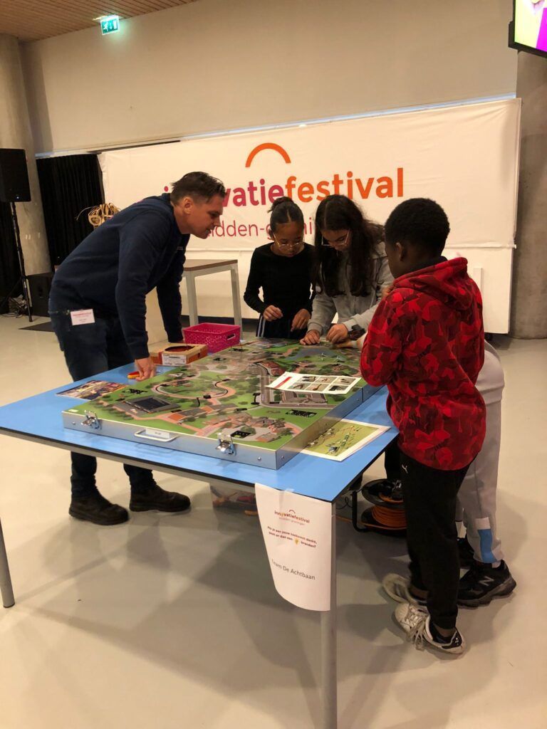 Onder toeziend ook van Alger Snijder van Enexis leggen leerlingen een energienetwerk aan in een woonwijk