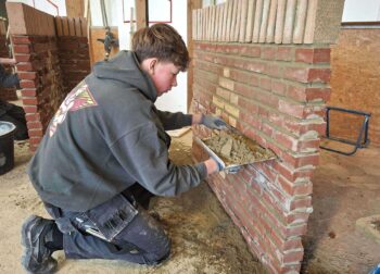 Jasper metselt een muur in kruisverband tijdens de SSPB metselwedstrijd