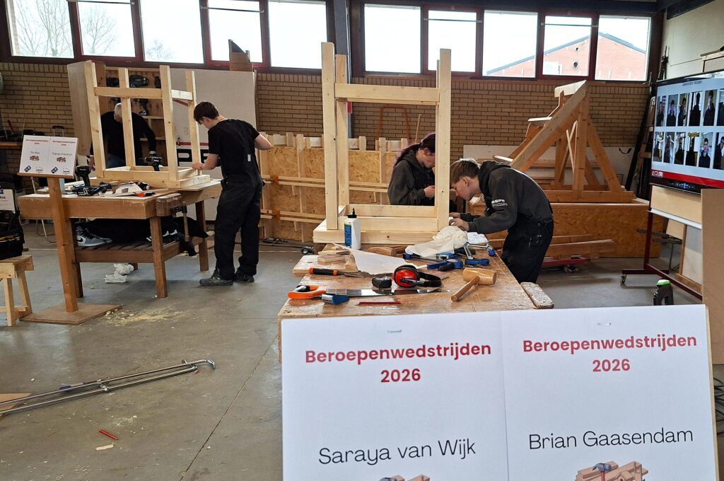 Timmerleerlingen werken aan het onderstel van de statafel tijdens de SSPB wedstrijd
