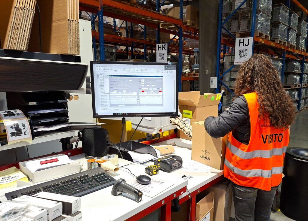 Leerling stelt een verzenddoos samen en verpakt een bestelling tijdens de logistieke opdracht.
